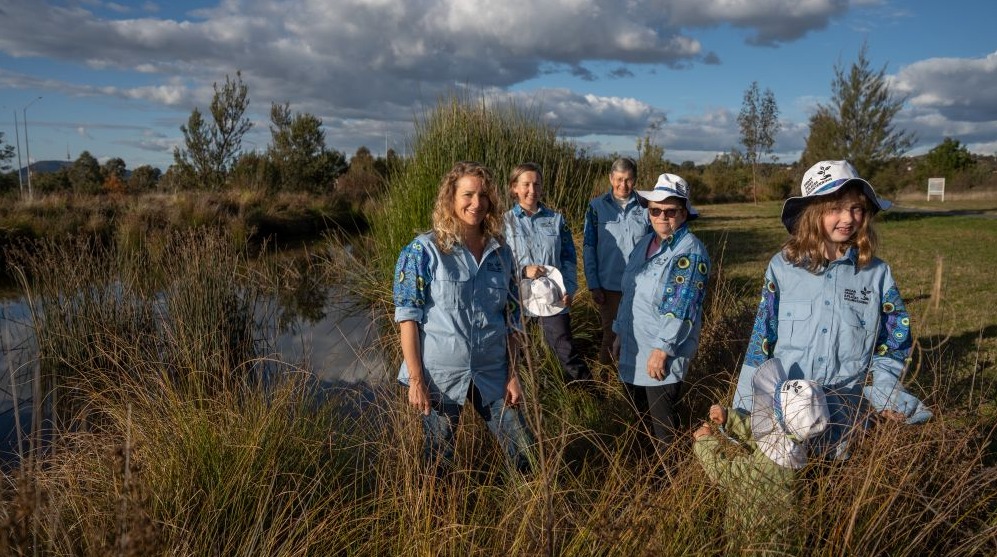 A group of people standing in wetlands.
