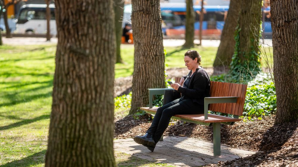 A woman sits on a park bench.